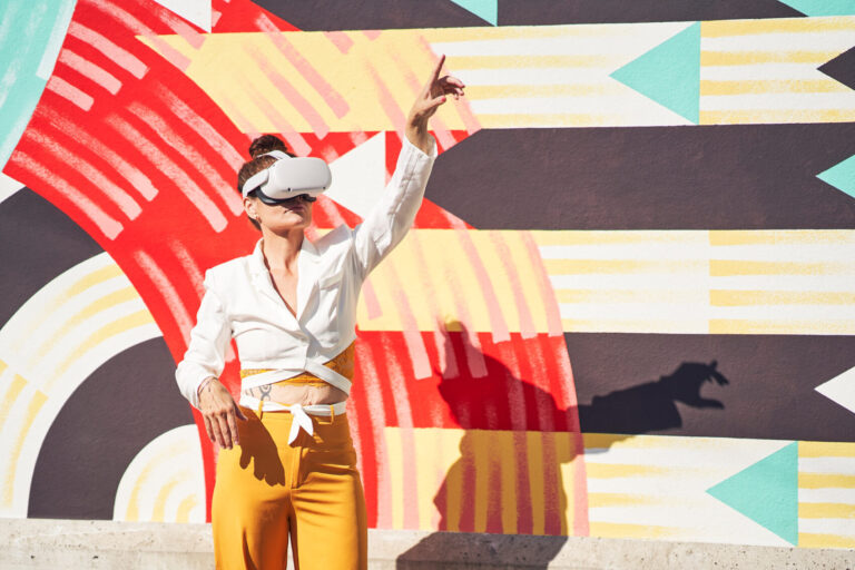 Eine Person mit VR-Brille zeigt in die Luft.