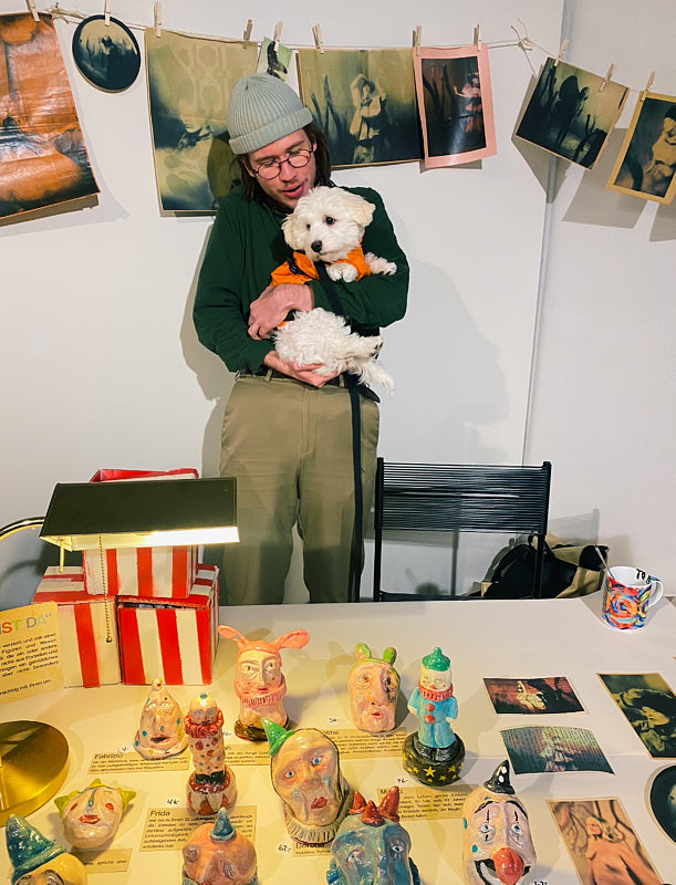 Dave mit einem Hund im Arm am Kunstbazaar.